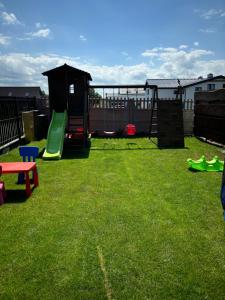 a yard with a playground with a play set at Tęczowe Lato in Sarbinowo
