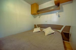 a bedroom with a bed with two pillows on it at Manoir le Mingreaud Bungalows in Sainte-Gemme-la-Plaine