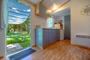 a kitchen with a large window and a large kitchen with a counter at Manoir le Mingreaud Bungalows in Sainte-Gemme-la-Plaine +18 photos