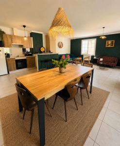 a kitchen and dining room with a wooden table and chairs at Les Terrasses du Vercors in Beauregard-Baret +29 photos
