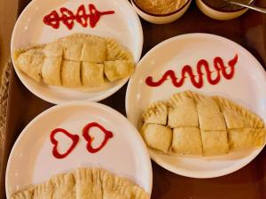 a table with plates of food with red writing on them at Above & Beyond - Tirthan in Banjār
