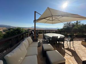 a patio with a couch and a table and an umbrella at Hogar del Sol in Pamplona