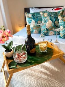 a table with a bottle of wine and glasses on a bed at Rebecca's Noir Suite in Reggio Emilia