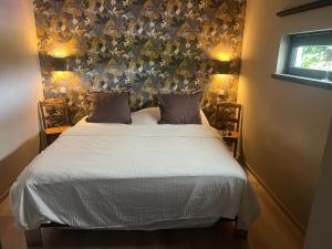 a bedroom with a bed with a floral headboard at coin détente in Juprelle