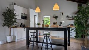 a kitchen with a black island with two bar stools at Villa Capelinhos in Capelo