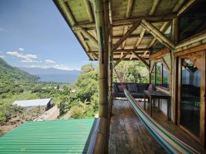 a porch of a house with a hammock on it at Bambu Guest House in Tzununá