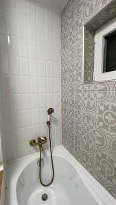 a bath tub in a bathroom with a tile wall at Studio Rodica in Zalău +2 photos