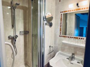 a bathroom with a shower and a sink and a mirror at Hôtel Le Siècle in Mazan +53 photos