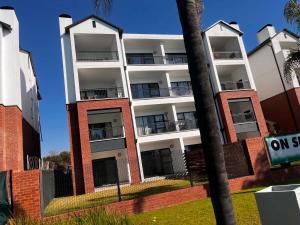 an apartment building with balconies on the side of it at Cozy&Pristine The Blyde in Pretoria
