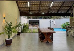 a room with a table and chairs and a pool at Residência Araguaia in Aruanã