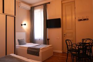 a bedroom with a bed and a window with a table at Hotel Ticiani 15 in Kutaisi