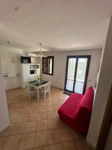 a living room with a red couch and a table at La CASA DI LUDO in Bernalda