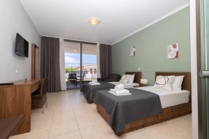 a hotel room with two beds and a desk at Centrum Rooms in Kallithea Halkidikis