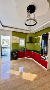 a kitchen with red cabinets and green walls at David Home in Danang