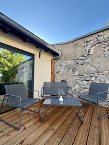a patio with three chairs and a table on a deck at Duplex appartement en plein centre in Gérardmer