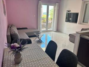 a living room with a couch and a table with flowers on it at Apartments Pletikosa in Brodarica