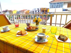 a yellow table with plates of pastries and coffee cups at B&B Profumo di Zagara in Taormina
