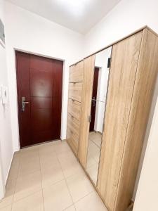 a room with a wooden door and a mirror at Apartman Centar Agrokop in Trebinje +3 photos