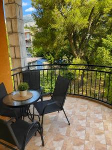 a balcony with a table and chairs and a fence at Apartman Centar Agrokop in Trebinje