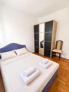 a bedroom with a large bed with two towels on it at Apartman Centar Agrokop in Trebinje