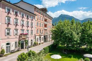 an empty street in a town with pink buildings at Hotel Liberty in Levico Terme