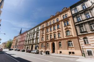 a building on a street with cars parked on the street at Gem Stone City Center in Olomouc