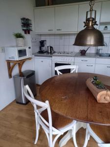 a kitchen with a wooden table and white cabinets at Boszicht in Elim +16 photos