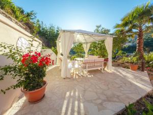 ein Pavillon mit einer Bank und Blumen auf einer Terrasse in der Unterkunft Orama Parga in Parga