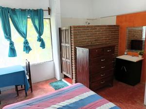a bedroom with a bed and a dresser and a window at Casa Tania in Mazunte