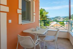 Ein Tisch und Stühle auf einem Balkon mit Aussicht in der Unterkunft Orama Parga in Parga