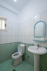 a bathroom with a toilet and a sink at Serxhio Apartments in Golem +62 photos