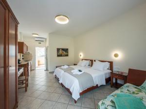 ein Hotelzimmer mit zwei Betten und einer Küche in der Unterkunft Orama Parga in Parga + 3 Fotos