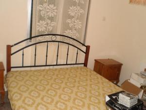 a bedroom with a bed and a window with a curtain at jenny's apartment in Vrontádos