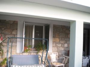 a screened in porch with chairs and a window at jenny's apartment in Vrontádos