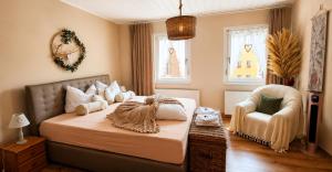 a bedroom with a bed and a chair and windows at Ferienwohnung Schmidtalien,inklusive Infrarotsauna in Dommitzsch