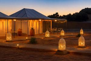 a marquee with lights in the desert at night at Sahara Nights Luxury Camp in Merzouga