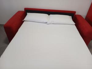a red bed with two pillows on top of it at Domus NAUSICA in Cologno al Serio
