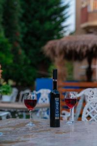 a bottle of wine sitting on a table with two glasses at Serxhio Apartments in Golem