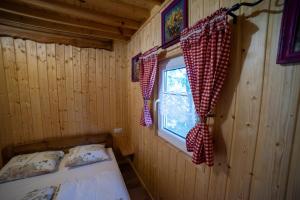 a bedroom with a bed and a window with checkered curtains at Zielone okiennice in Chobie
