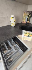 a kitchen counter with a sink with utensils in it at Yellow Apartment Mažeikiai in Mažeikiai +8 photos