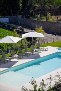 a swimming pool with chairs and umbrellas at Lourença Stays - Quinta Lourença in Vilar +37 photos
