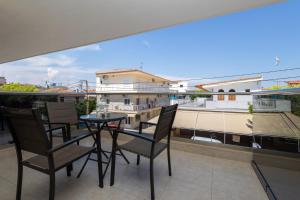 a balcony with a table and chairs and a view of a building at Centrum Rooms in Kallithea Halkidikis