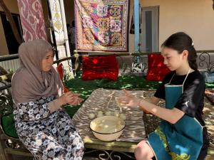 two women are standing next to a table with eggs at Gulzar Village Guesthouse in Dushanbe
