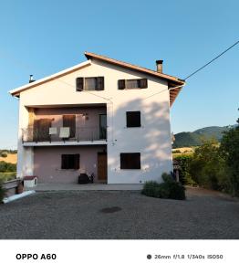 a white building with a balcony on the side at MANSARDA VITI - Sguardo su Frontone - in Frontone