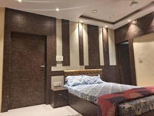 a bedroom with a bed and a wall with stripes at Mavenoak Dreams B&B in Kolkata