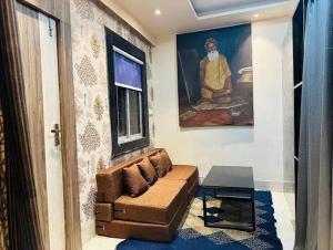 a living room with a couch and a painting at Mavenoak Dreams B&B in Kolkata
