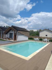 a large blue swimming pool with a wooden deck at Danube Delta Bungalows Gorgova in Gorgova