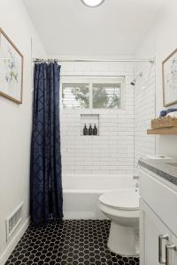 a bathroom with a white tub and a toilet at Italian Cottage 2B 1B Duplex KING Pet Friendly in Richardson