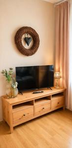 a flat screen tv sitting on top of a wooden entertainment center at Ferienwohnung Schmidtalien,inklusive Infrarotsauna in Dommitzsch