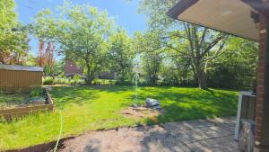 a yard with a hose in the grass at CozyHaven in St. Catharines